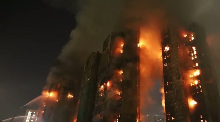 Противпожарни екипи пред оштетен станбен комплекс во Хонг Конг